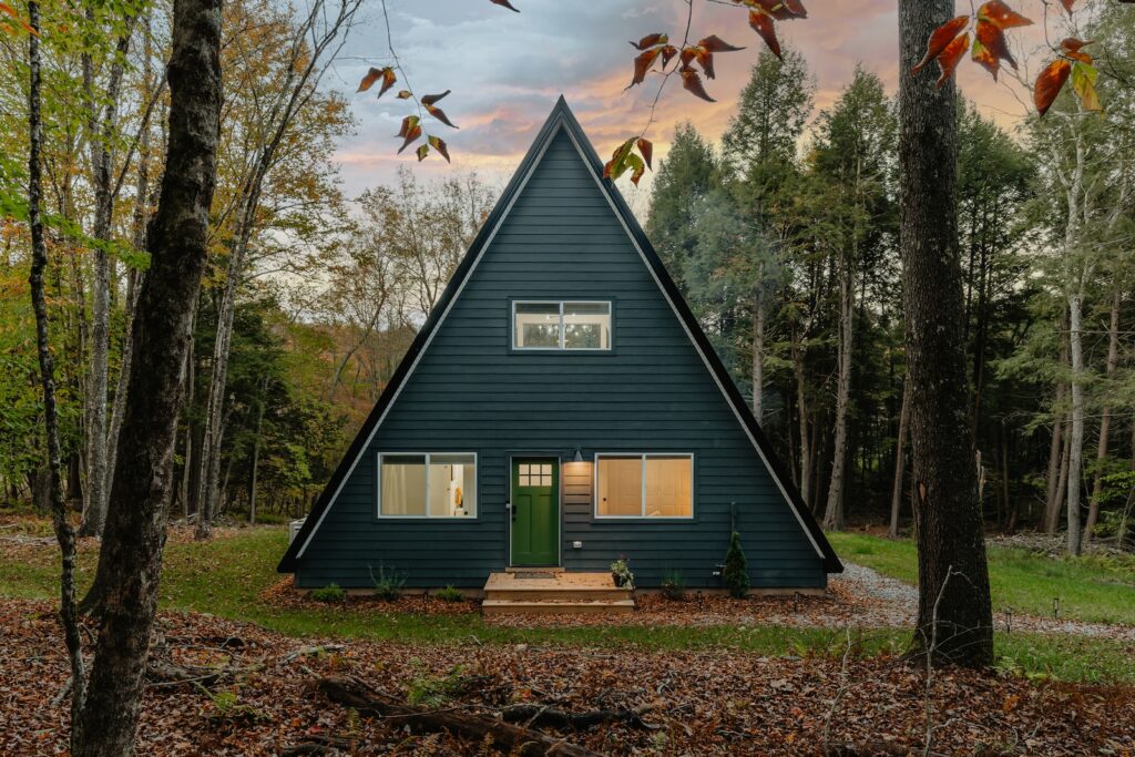 a - frame cabin in the woods with a green door